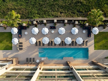 Una piscina al aire libre, sombrillas, tumbonas