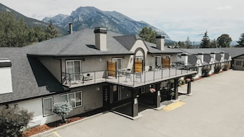 A couple on a balcony overlooking a mountainous landscape, with a sign reading "Northwind" and outdoor seating.