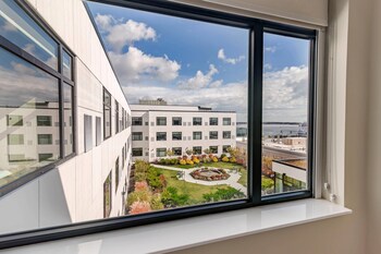 Una terraza en la azotea con un área de estar exterior moderna, un hogar para fuego y vistas de la ciudad.