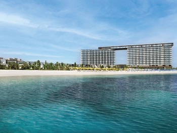 A beachside lounge with wicker furniture, a wooden deck, and a view of the sea.
