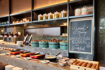 Montaje de desayuno tipo buffet con diversos alimentos y recipientes.