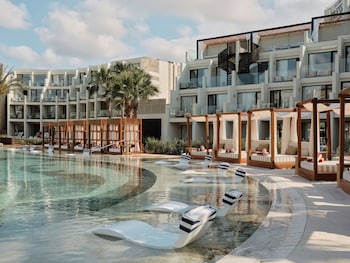Ein Resort mit Swimmingpool, mehreren Balkonen und Palmen.