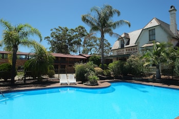 A swimming pool with lounge chairs, a building labeled "Gold Wheel Country Restaurant," and surrounding greenery.