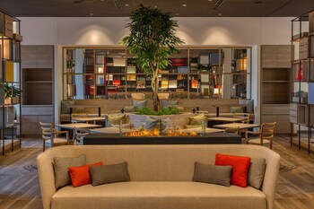 Relax in a comfortable space with seating areas, tables, and a sofa, surrounded by plants and decorative items.