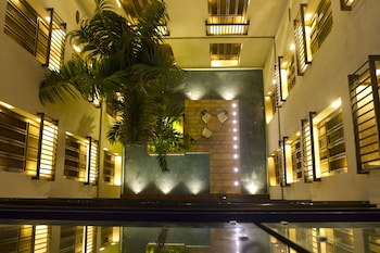 A swimming pool with clear water, surrounded by lush greenery and flowering plants.