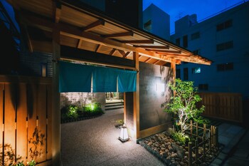 A covered outdoor area with a wooden pergola, a lantern, and a small tree.
