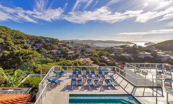 Una terraza de madera con un jacuzzi, una mesa y sillas, con vistas a un paisaje exuberante.