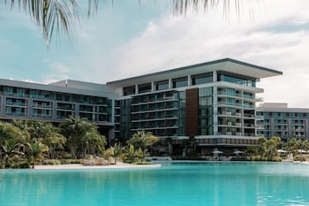 A resort with multiple swimming pools, lounge areas, and a modern building with balconies.