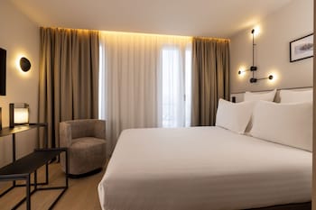 Un espace spa moderne doté d’un mur en verre, de lambris en bois et d’un coin salon.