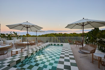 Alberca al aire libre, sombrillas en la alberca y camastros