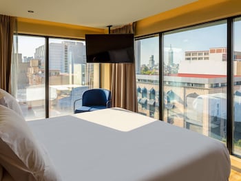A hotel with a modern facade, large windows, and a well-maintained outdoor area with plants.