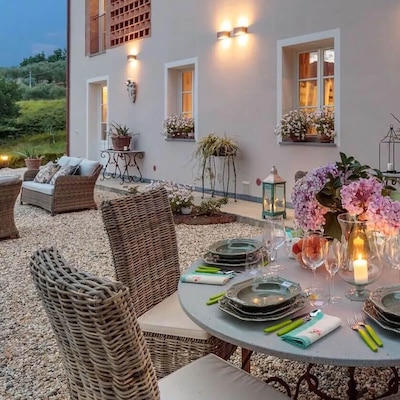 Au crépuscule, sur le patio extérieur d’une chaleureuse location de vacances, une table est servie pour le dîner.