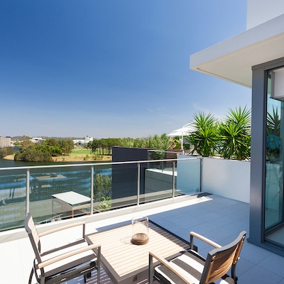 Small balcony overlooking the suburbs in the Gold Coast of Australia, featuring a rooftop patio and telescope inside the house.