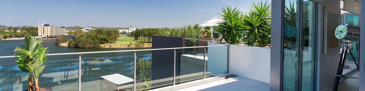 Small balcony overlooking the suburbs in the Gold Coast of Australia, featuring a rooftop patio and telescope inside the house.