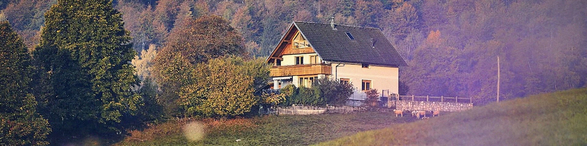 Ein Haus mit Blick auf einen Pool, über grüne Landschaften und bis zum dahinter liegenden Meer.