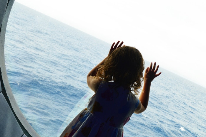 Child looking out window to sea