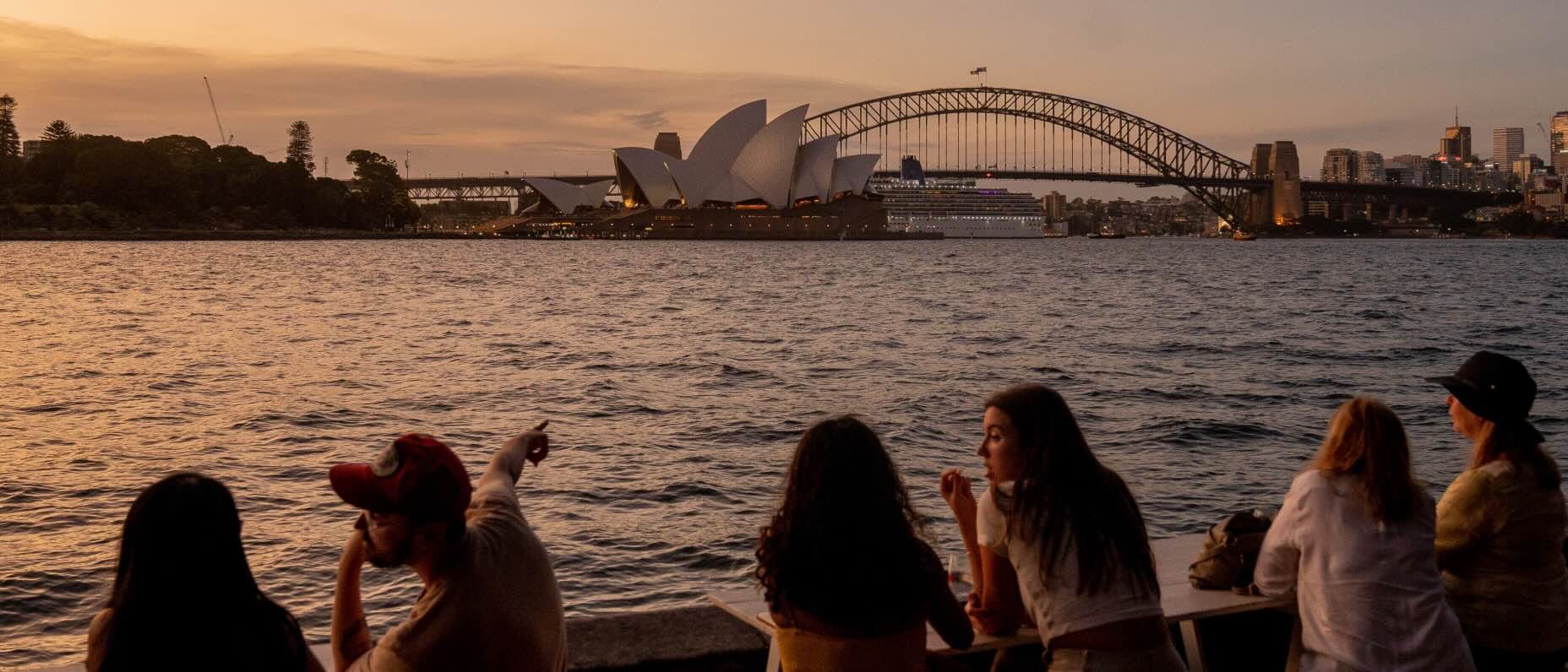 Visitors to Sydney look across the water to the city’s famed Harbour Bridge and opera house