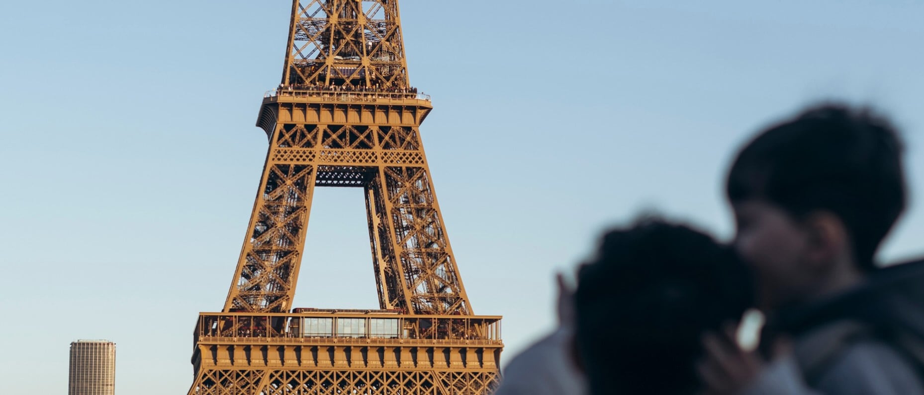 Zwei Personen stehen vor dem Eiffelturm in Paris