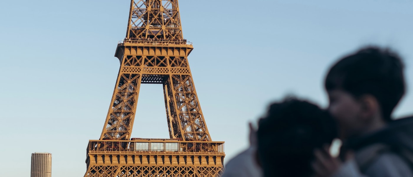 Dos personas de pie enfrente de la torre Eiffel en París