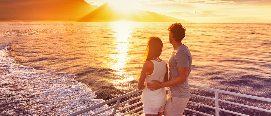 Passengers recline on deck chairs as they take in ocean views aboard a cruise ship.