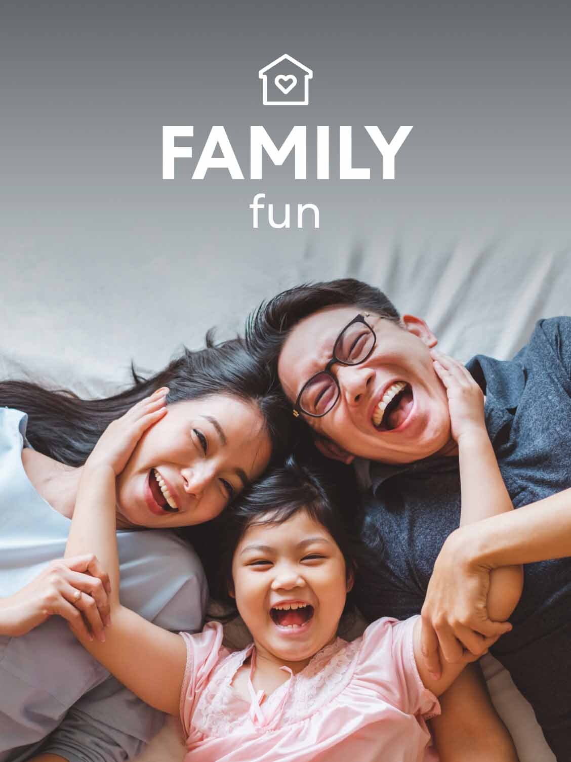 A mother - father and daughter lay with their heads together on the bed - laughing. A superimposed title reads: Quality family time.
