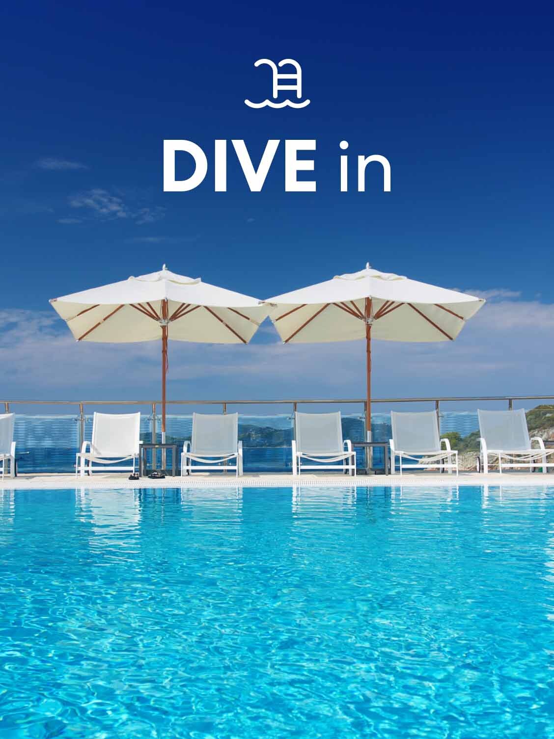 View from an empty swimming pool looking towards empty poolside tables with umbrellas. A superimposed title reads: Dive in.