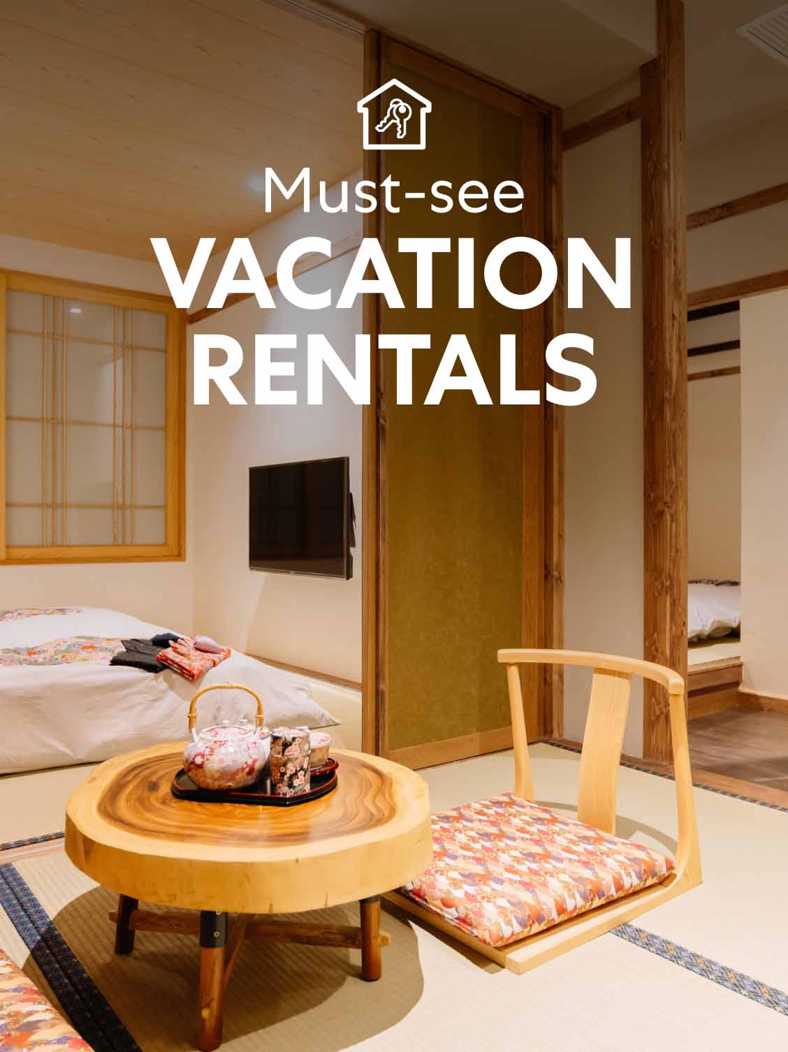 Interior view of a Japanese-style hotel room. Screens are set up to separate areas. A small floor table and chair sit in the forefront - a low bed in the background. A superimposed title reads: Must-see vacation rentals.