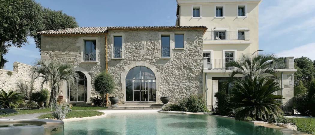 Exterior view of the a building and outdoor pool of Domaine de Verchant Hotel and Spa.