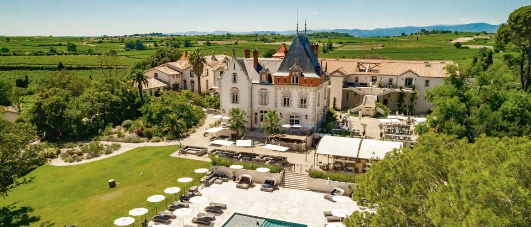 Aerial view of the grounds of the Château Saint Pierre de Serjac surrounded by vineyards and gardens.