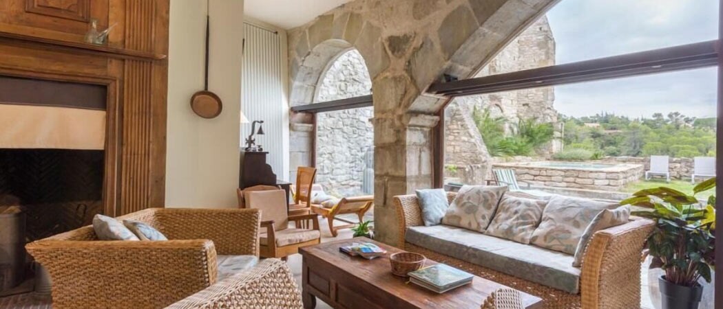 Interior view of a lounge setting beside a large window looking out to a garden and spa at the Château Asturias in Aragon.