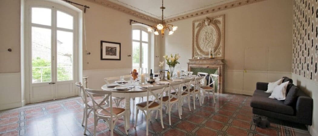 Interior view of a large dining room with a table set for twelve guests at the Le Manoir in Canet d’Aude.