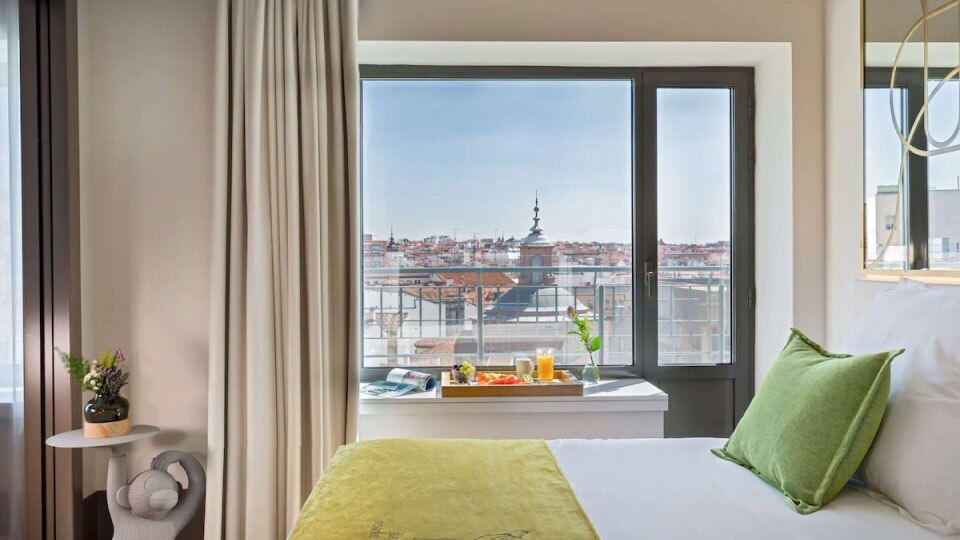 Gros plan sur une chambre avec un lit avec des draps blancs