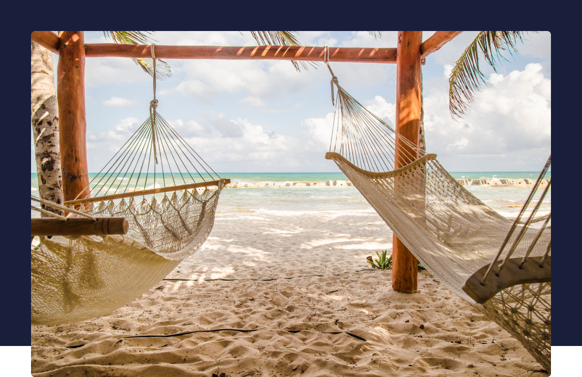 "A tropical beach with two hammocks "