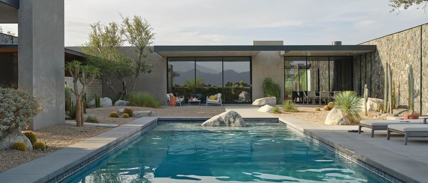 Contemporary house with a clear blue pool and a stylish patio, ideal for enjoying sunny days and outdoor gatherings.
