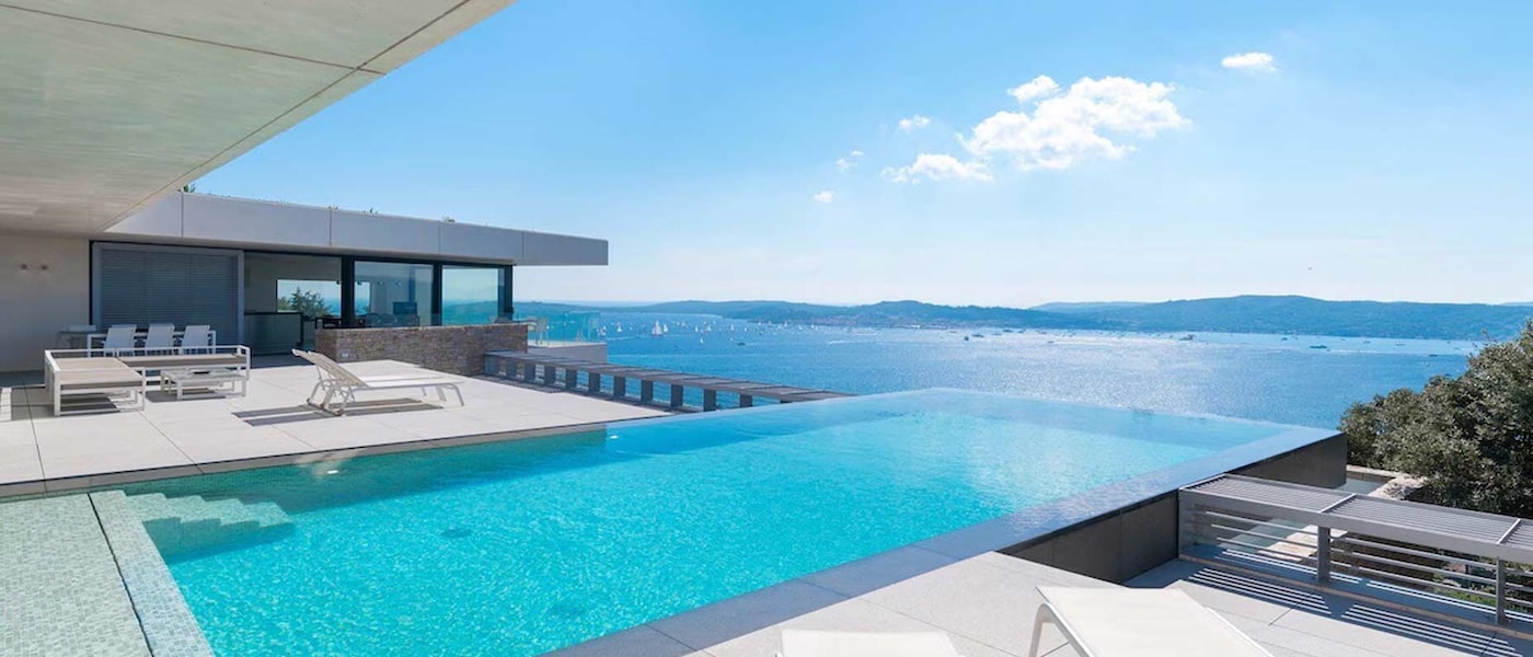In a luxury villa in St Tropez, an infinity pool looks out over the Mediterranean sea and St Tropez harbour.