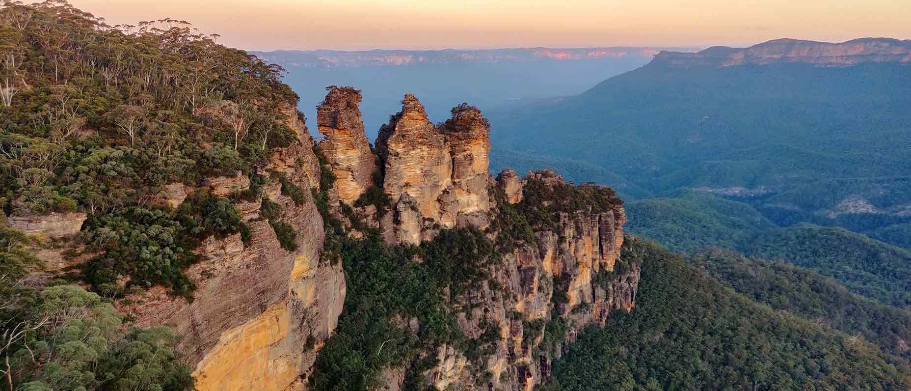A mountain view with rock formations and a beautiful valley below