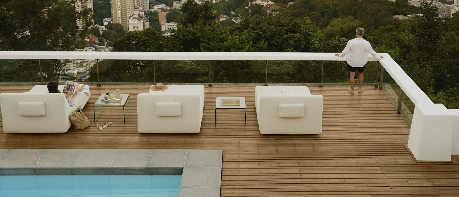 A couple relax on a rooftop pool overlooking the city. 