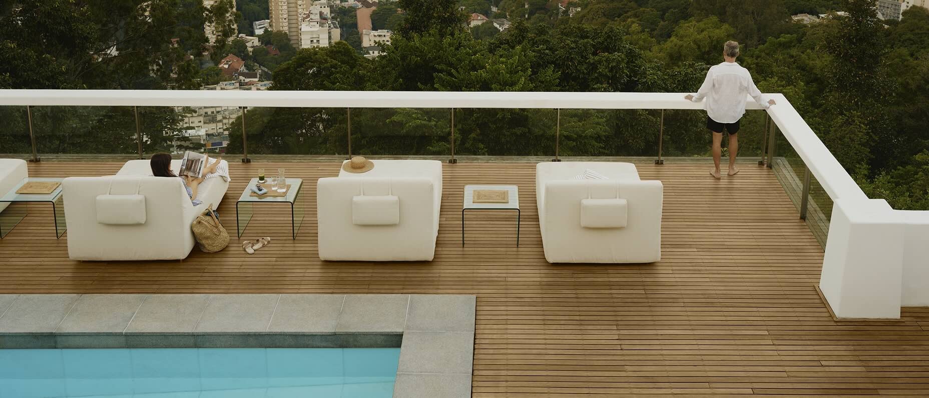 Casal relaxando em uma piscina na cobertura olhando para a cidade.