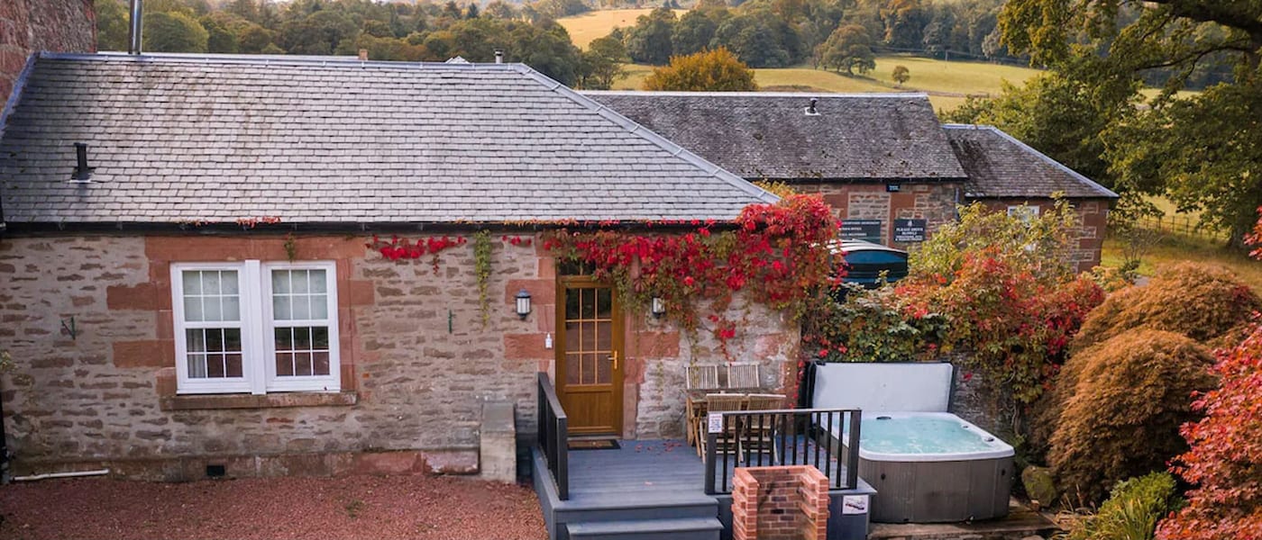 A traditional cottage in the English countryside surrounded by the colours of autumn.