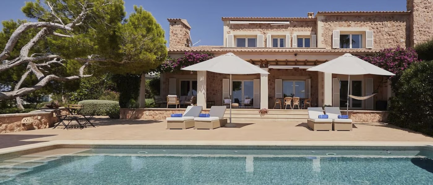 Lounge chairs line the pool at a gorgeous vacation rental