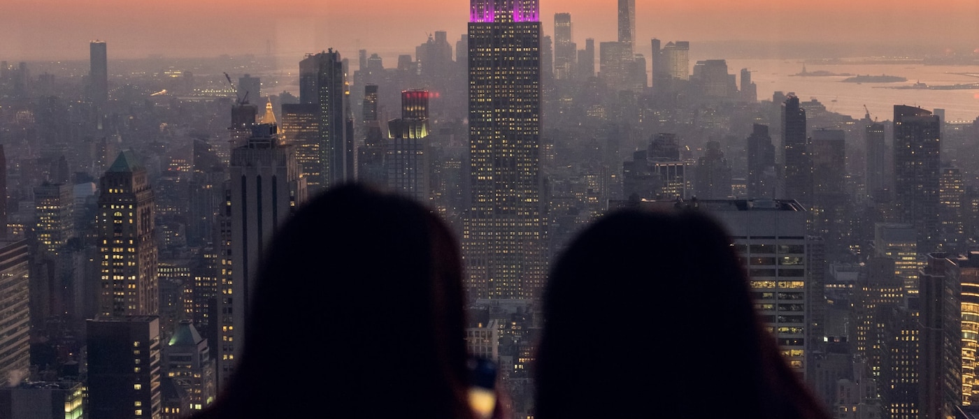 Dos personas contemplan el atardecer en Manhattan desde el mirador de un rascacielos