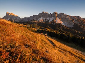 Couple of hikers in long sleeve and warm vests hiking down the countryside in Europe