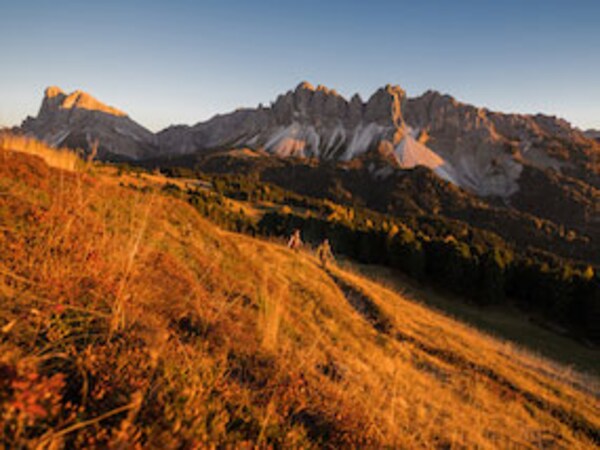 Couple of hikers in long sleeve and warm vests hiking down the countryside in Europe