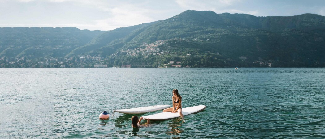 Dos mujeres plaing en sus botes de remos en el agua.