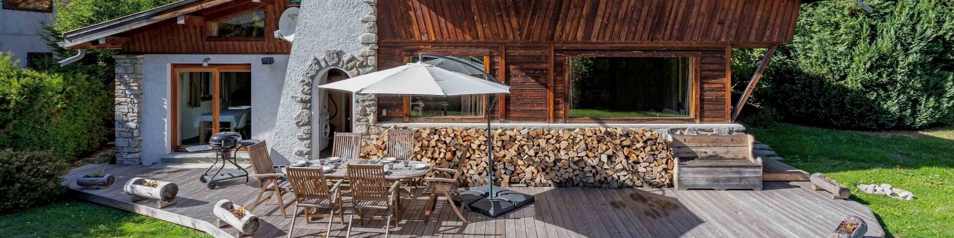 Un patio ensoleillĂ© Ă deux niveaux dispose dâune table, de chaises, dâune piscine, de chaises longues et dâun parasol.