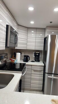 Full kitchen with electric stoves.