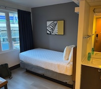 Simple comfortable single bed with desk, tv , sink and view of Roger’s Arena. Washroom & showers down the hall and kitchen prep on 7th floor.