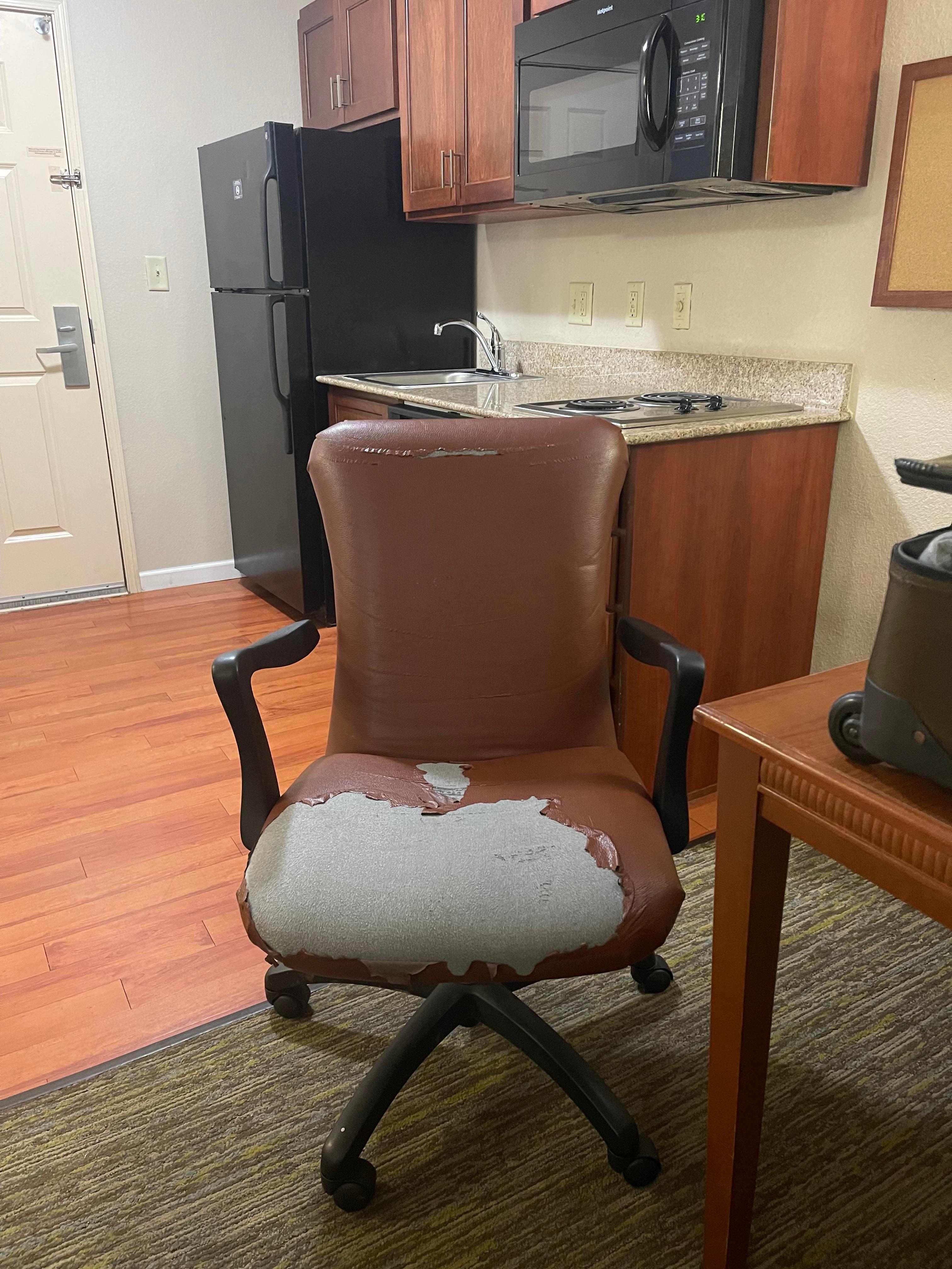 This is the chair by the table in the hotel room.
