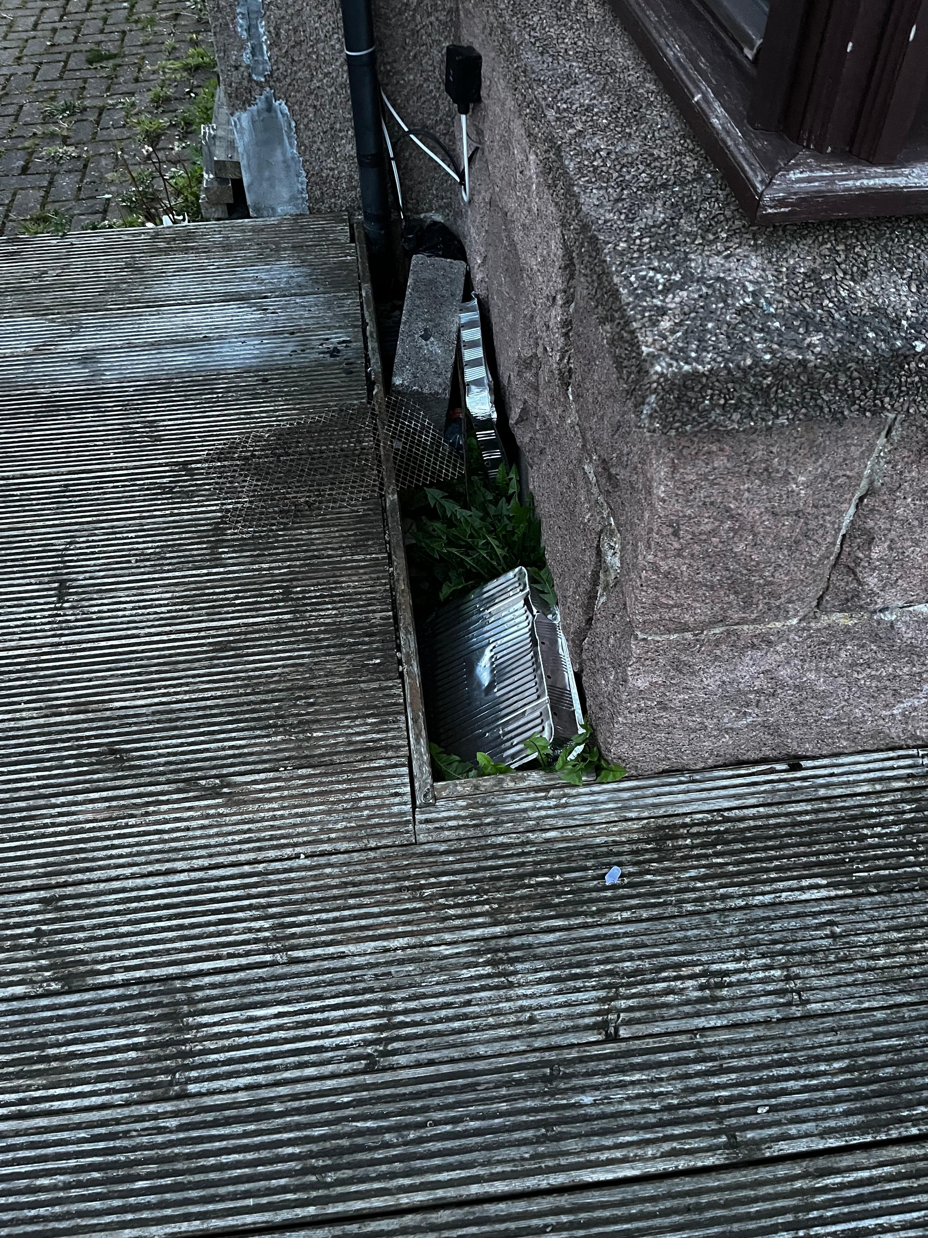 Discarded bbq trays beside front entrance 