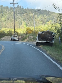 Abandoned vehicles on road before reaching the inn.